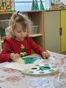 dziewczynka maluje kartkę na zielono