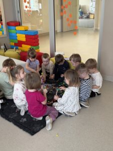 grupa dzieci siedząca na dywanie