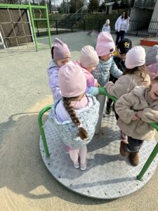 grupa dzieci stojąca na karuzelii
