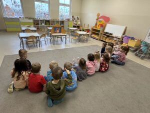 grupa dzieci siedzące na dywanie