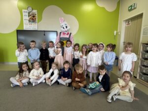 grupa dzieci stojąca z zajączkiem wielkanocnym.