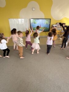 grupa dzieci przed ekranem wykonująca ćwiczenia