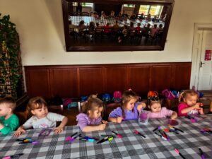 Dzieci siedzące przy stole wykonujące prace plastyczną