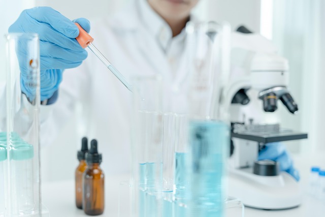 postać w stroju chemika trzymająca w ręku pipetę
