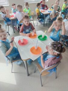 grupa dzieci siedząca przy stolikach