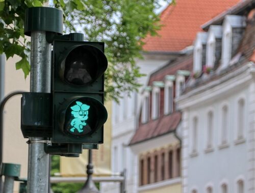 sygnalizacja świetlna, wskazujący zielone światło w tle widać budynki