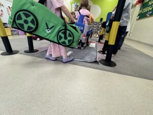 dzieci przebrane w samochody jeżdżące po zabawkowej drodze